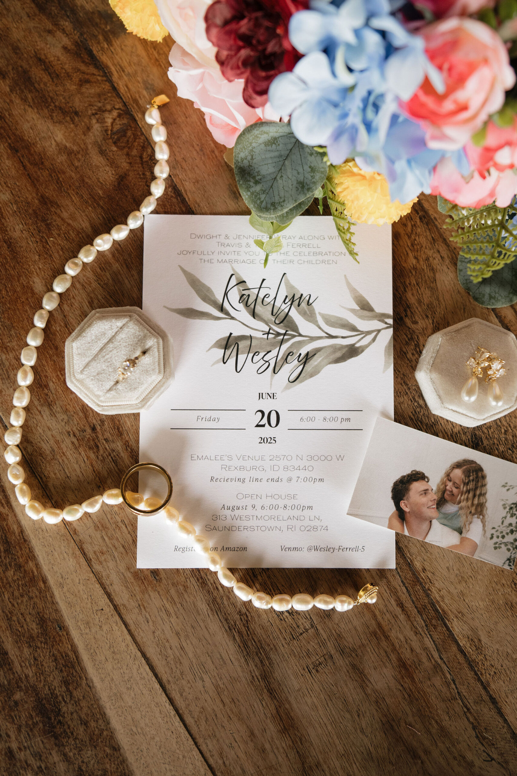 Wedding flatlay against a wooden table with colorful flowers and wedding jewelry