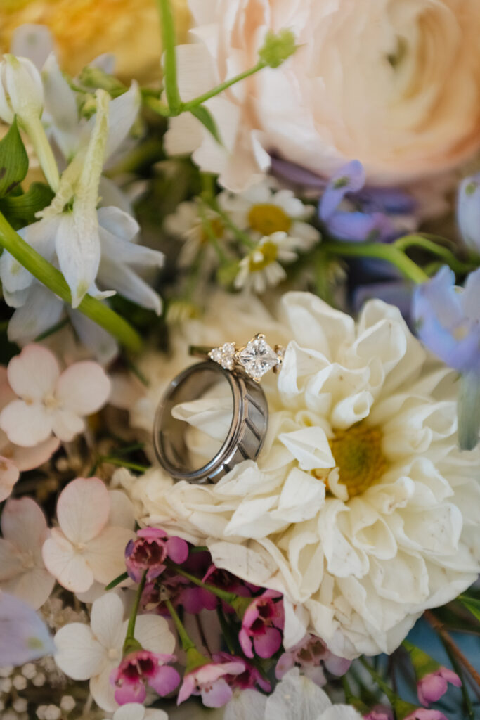 Two wedding rings placed on the white flower in the bride's bouquet.